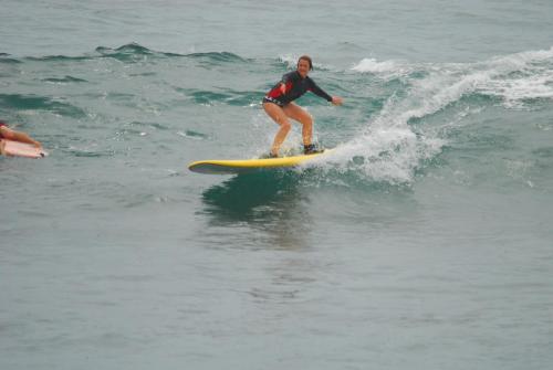 a woman riding a wave on a surfboard in the ocean at Cabo Surf Hotel in San José del Cabo