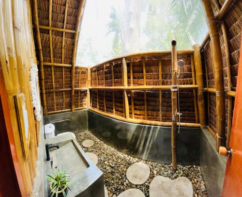 a bathroom with a bath tub in a bamboo house at MAAYONG HOSTEL in Moalboal