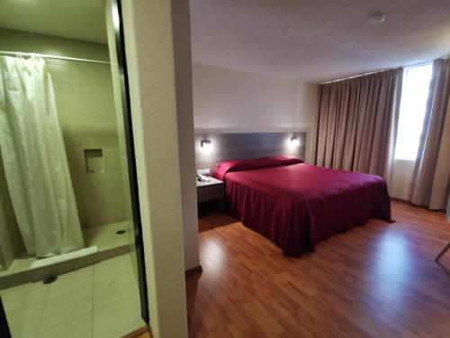 a bedroom with a bed with a red bedspread at Hotel Del Angel Reforma in Mexico City