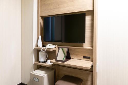 Habitación con TV y escritorio con monitor. en R&B Hotel Higashi Nihonbashi, en Tokio