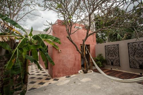 a house with a tree and a fence at Luxury home in the heart of Merida Centro in Mérida