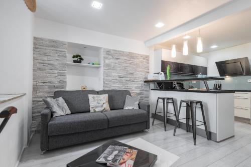 un salon avec un canapé et une cuisine dans l'établissement Amazing 3 Bdrs and Garden Place du Pin Parking !, à Nice