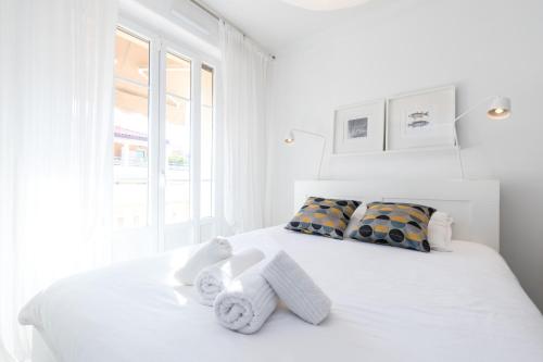 - une chambre blanche avec un lit blanc et des serviettes dans l'établissement Cosy 1 Bdr near Garibaldi Square - Top Floor & AC, à Nice