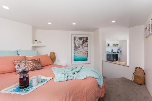 Un dormitorio con una cama y una bandeja. en Naxos - Med style castle, ocean views from every room! en Bowentown