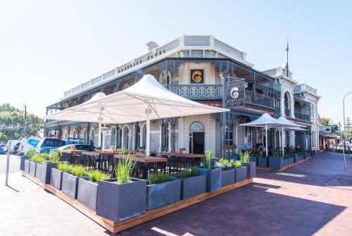 a restaurant with tables and umbrellas in front of a building at Ramsgate Hotel by Nightcap Social in Adelaide