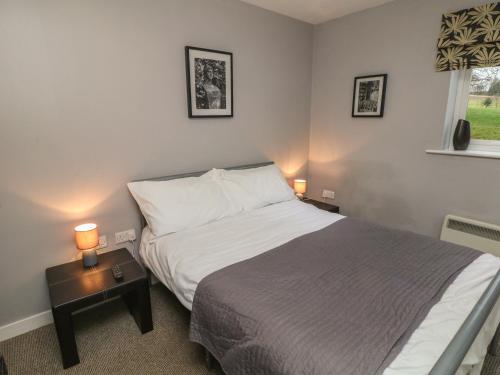 a bedroom with a bed and two lamps on a table at Bunbury in Alton