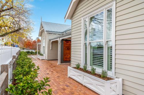 a home with a brick walkway next to a house at Grandview Accommodation - The Elm Tree Apartments in Mount Barker