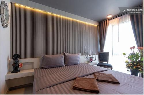 a bedroom with a large bed with two towels on it at The Diamond 789 Minburi in Bangkok