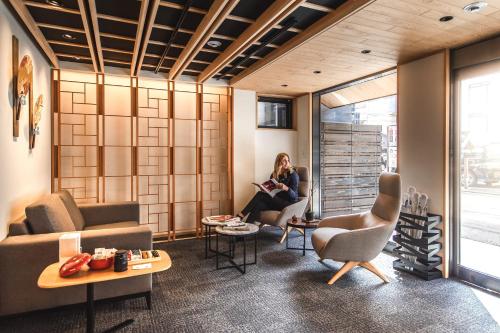 a woman is sitting in a waiting room at Miru Kyoto Nishiki in Kyoto