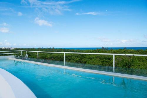 una piscina con vistas al océano en Oceanview Luxury Suite Steps from Quinta Avenida Balcony Infinity pool HMoon, en Playa del Carmen