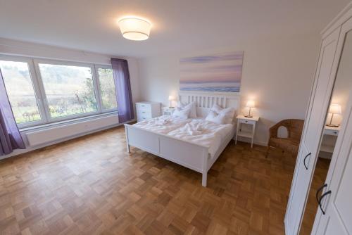1 dormitorio con cama blanca y ventana grande en Gästehaus Albero, en Lindau