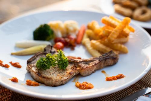 a plate of food with meat and french fries at Ayara Villas - SHA Extra Plus in Khao Lak