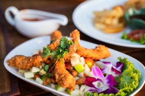 a plate of food withfried foods and vegetables on a table at Ayara Villas - SHA Extra Plus in Khao Lak
