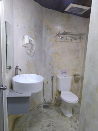 a bathroom with a toilet and a sink at Rick Resort Teluk Intan in Teluk Intan