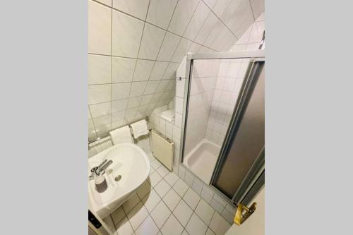y baño blanco con lavabo y ducha. en Kuscheliges Sylt Zuhause für 2 Personen en Westerland