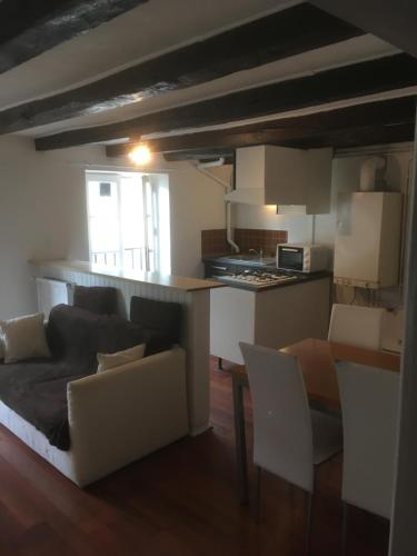 uma sala de estar com um sofá e uma cozinha em Victor Hugo 3 G sa pizza offerte em Aurillac
