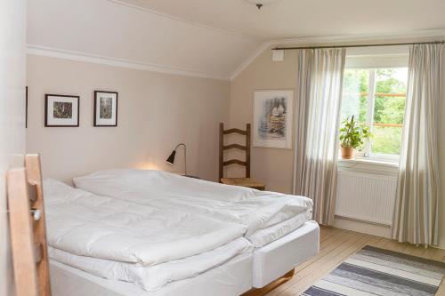 1 dormitorio con cama blanca y ventana en Löfwings B&B, en Broddetorp