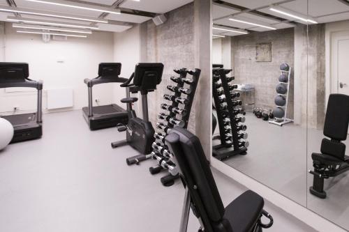 a gym with rows of tread machines and a mirror at Hotel Ottilia in Copenhagen
