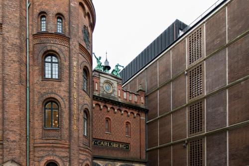 un grand bâtiment en briques avec une horloge en haut dans l'établissement Hotel Ottilia by Brøchner Hotels, à Copenhague