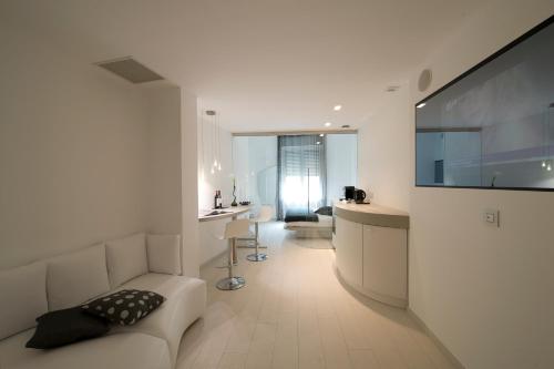 a living room with a white couch and a television at Aparthotel Duomo in Milan