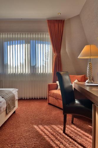 a hotel room with a desk and a bed and a chair at ART-Hotel Braun in Kirchheimbolanden