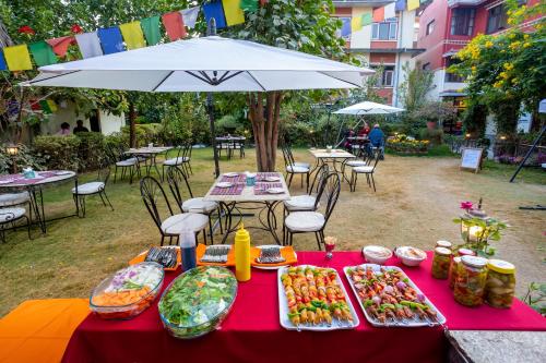 a table with plates of food on it with an umbrella at ROKPA Guest House in Kathmandu