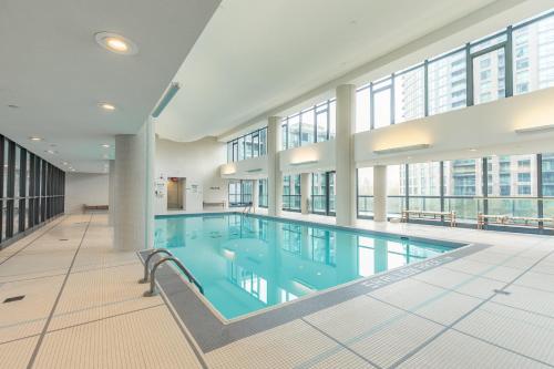 een groot zwembad in een gebouw met ramen bij GLOBALSTAY Magnificent Condos in DT in Toronto