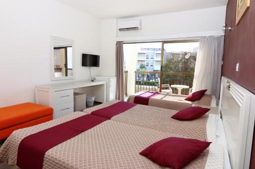a hotel room with two beds and a balcony at King's Hotel in Paphos