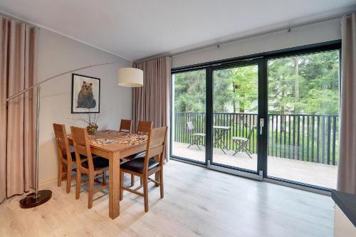 jadalnia ze stołem i balkonem w obiekcie Ekskluzywny Apartament Sun Seasons 24 w Karpaczu by Noclegi Renters w mieście Karpacz