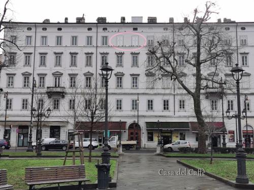 a large white building with a pink sign on it at Casa del Caffè in Trieste