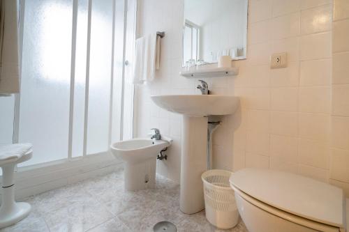 La salle de bains blanche est pourvue d'un lavabo et de toilettes. dans l'établissement Hotel Nido, à La Corogne