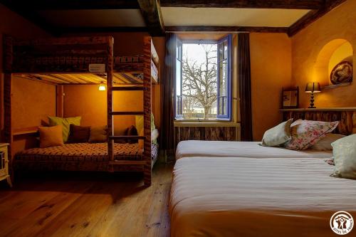 a bedroom with two bunk beds and a window at Goute la vie in Marchamp