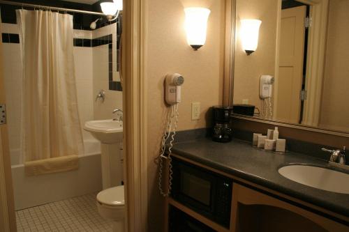a bathroom with a sink and a phone on the wall at Ambassador Hotel Milwaukee, Trademark Collection by Wyndham in Milwaukee