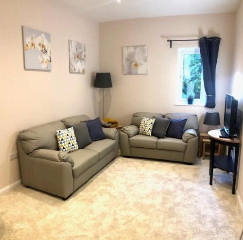 Private 1st Floor Apartment - Perfect for Port of Dover, Eurotunnel and Short Stays في دوفر: غرفة معيشة بها كنبتين وتلفزيون