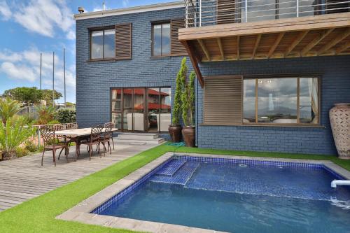 a house with a swimming pool in front of a house at The Whale's Tale Guesthouse in Hermanus