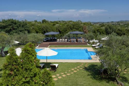 an overhead view of a swimming pool with an umbrella at Beautiful 9-Bed Villa in Gouvia with Tennis Court in Gouvia