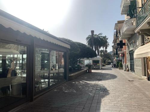 an empty street with shops and a palm tree at Casa Marino by Holiday World in Cogoleto