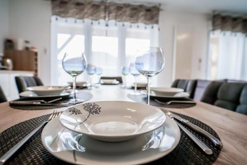 - une table avec une assiette et des verres à vin dans l'établissement Apartment for 4 people with condominium parking, à Lathuile