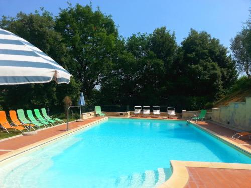a large swimming pool with chairs and an umbrella at Residence Le Meridiane in Siena