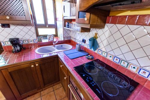 uma cozinha com um lavatório e um fogão forno superior em Casa Rural Abuelo Ramón em Vallehermoso
