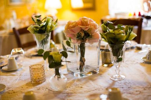 a table with three vases with flowers in them at Dimora di Charme Villa Sant'Erasmo in Fumone