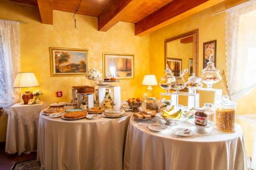una sala da pranzo con due tavoli con sopra del cibo di Dimora di Charme Villa Sant'Erasmo a Fumone