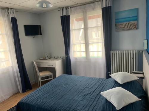 um quarto com uma cama azul e uma secretária em Au Vieux Puits em Villers-Bocage