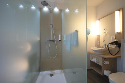 bagno con doccia in vetro e lavandino di Hotel Deutsches Haus a Gifhorn
