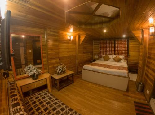 a bedroom with a bed in a wooden cabin at Hotel Broadway Anneexy in Darjeeling