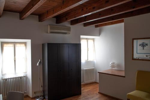 a living room with a black cabinet and two windows at Alla Piazzetta del Castello in Cernobbio