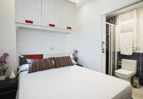 1 dormitorio con cama blanca y aseo en MIT House Salamanca Confort X en Madrid, en Madrid