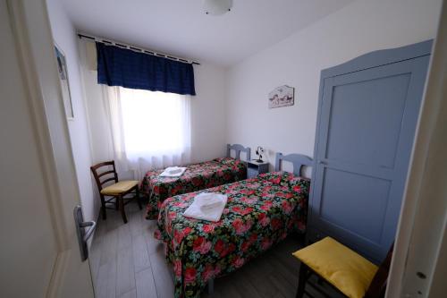 a small room with two beds and a window at Agriturismo Casale del Contadino in Bolsena