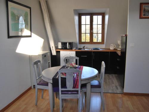 une salle à manger avec une table et des chaises et une cuisine dans l'établissement Gîte L'Arquebuse, à Troyes