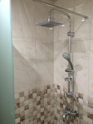 a shower with a glass door and a shower head at Apartment Perfect in Pomorie